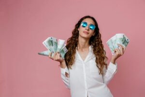 donna con occhiali da sole e con tante banconote nelle mani