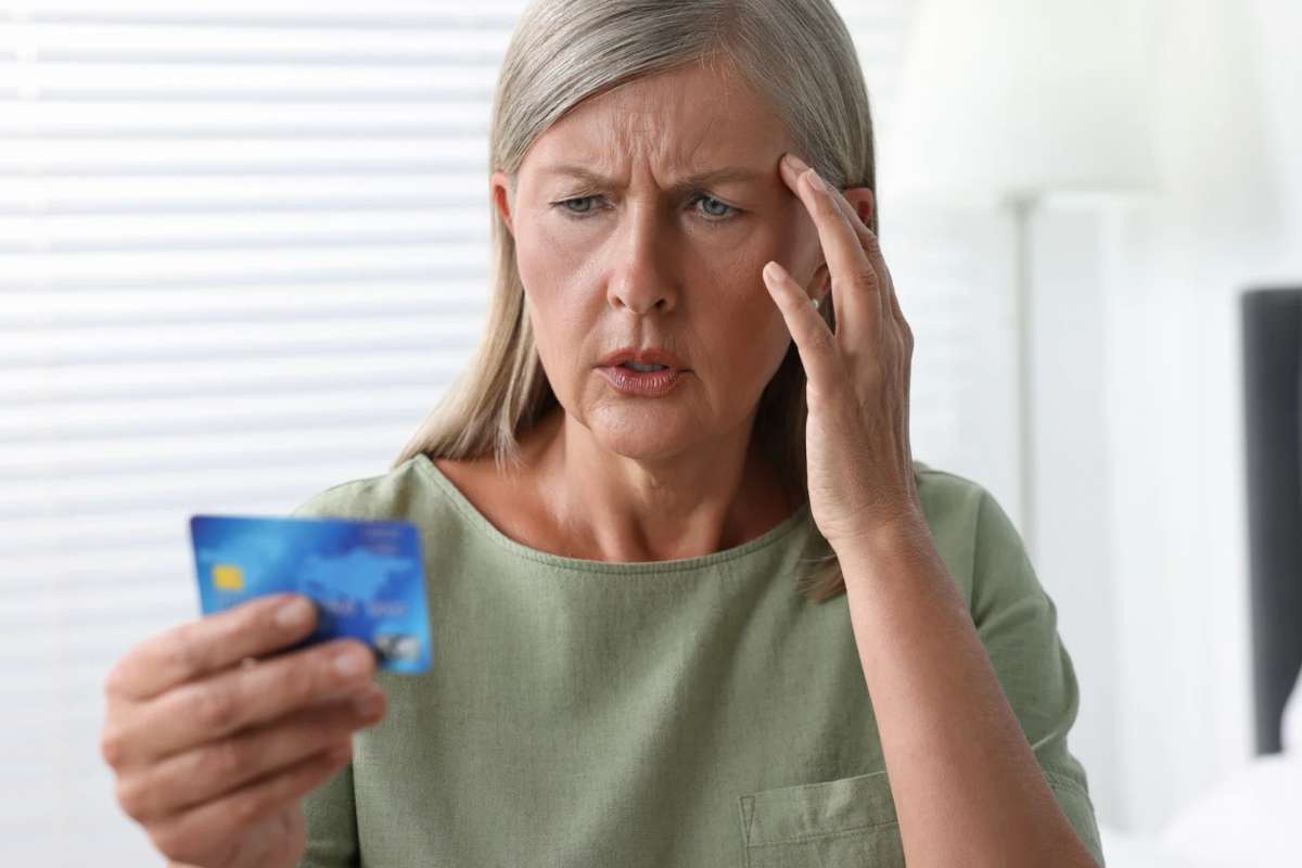 Donna preoccuparta con carta di credito in mano