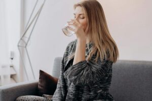Ragazza che beve un bicchiere di acqua