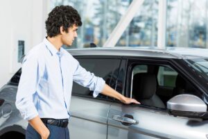 uomo guarda auto al concessionario