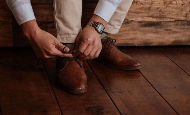 uomo si allaccia le scarpe