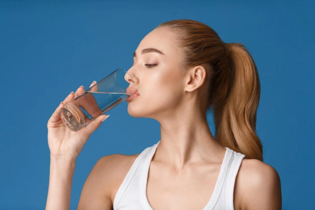 Donna che beve un bicchiere d'acqua